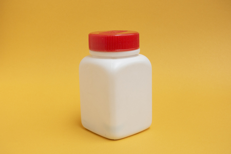 Close up white pill bottle on yellow backgroundの写真素材