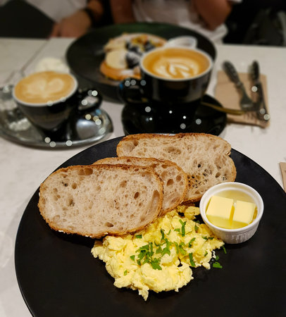 Healthy brunch with ciabatta, scrambled egg and butter. WIth a cup of latteの写真素材