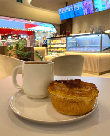 Freshly baked chicken mushroom pie and hot chocolate for breakfast. Warm toned led lighting. Cosy ambience.の写真素材