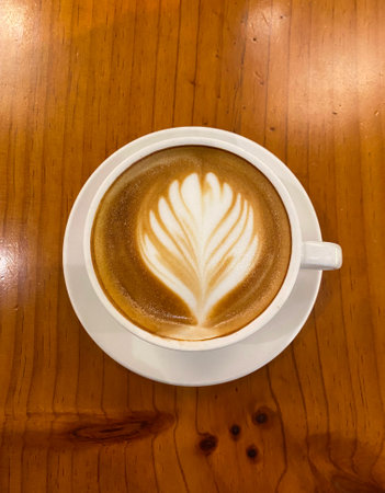 A cup of hot latte decorated with flower latte art.の写真素材
