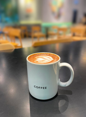 A cup of hot coffee in a white colour cup on a black colour table, blur background.の写真素材