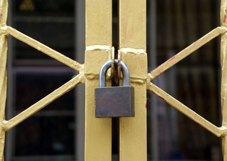 The lock on the gold metal fence, shape of the fence look like X.