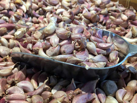 Pile red raw onion cloves on the metal scoop, Texture of red small onion petals on the steel ladle.の写真素材