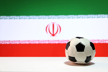 Small football on the white floor and Iranian nation flag background. The concept of sport.の写真素材