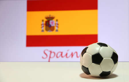 Small football on the white floor and Spanish nation flag with the text of Spain background. The concept of sport.の写真素材
