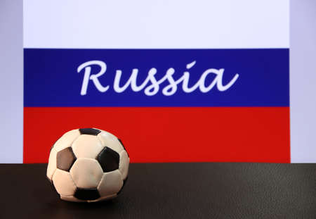 Small football on the black floor and Russian nation flag with the text of Russia background. The concept of sport.の写真素材