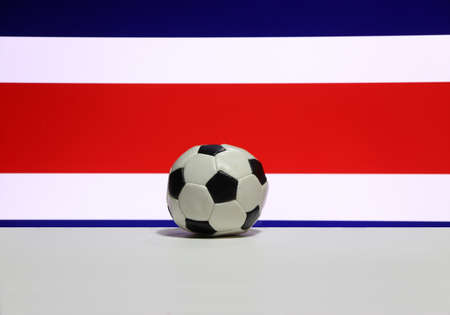 Small football on the white floor with white red and blue color of Costa Rican nation flag background. The concept of sport.の写真素材