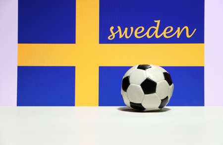 Small football on the white floor and Swedish nation flag with the text of Sweden background. The concept of sport.の写真素材