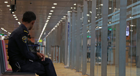 Yangon, Myanmar June 11, 2018: Airport Security in dark blue uniform sitting on the chair in the...