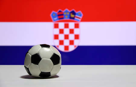 Small football on the white floor with out focus red white and blue color of Croatian nation flag background. The concept of sport.の写真素材