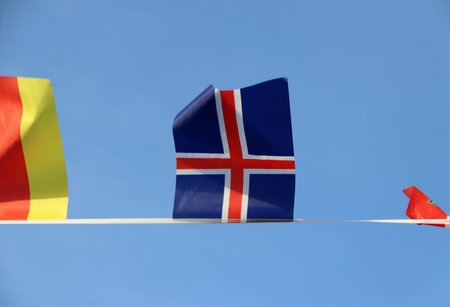 Mini fabric rail flag of Iceland in The Red Cross crosses over the white cross on the blue color...