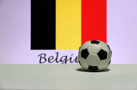 Small football on the white floor and Belgian nation flag with the text of Belgium background. The concept of sport, Belgium is one of the finalists in football tournament of the world.の写真素材