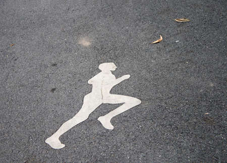The white jogging man painting on the jogging lane. run at a steady gentle pace, especially on a regular basis as a form of physical exercise.の写真素材