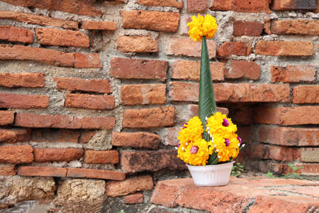 Rice offering from banana leaf and yellow marigold flower on the brick, it is one of the most important components of religious ceremonies of Thai.の写真素材