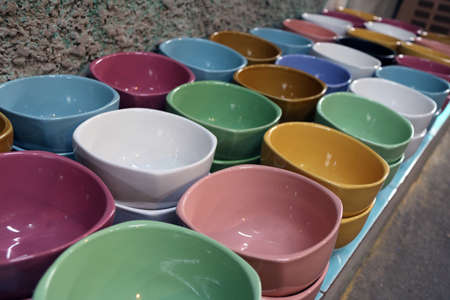 Row of colorful soup bowl on the floor. many color of bowl,  green, black, white, orange, pink, red, brown, blue and yellow color.の写真素材