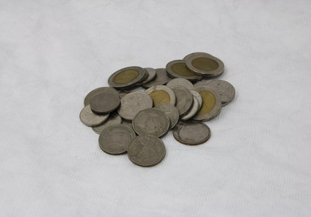 A pile of Thai bath coins. a flat, typically round piece of metal with an official stamp, used as...