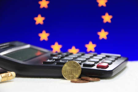 Ten Germany euro cent on obverse and two coin of two euro cent on white floor with black calculator and pencil, Euro flag background, the concept of finance.の写真素材