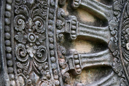 Close up stone carving of the wheel of the dharma. in archaeological site of Srithep ancient town in Petchaboon, Thailand. The influence of ancient Draravati culture, 8th-9th century A.D.のeditorial素材