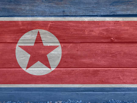 Flag of North Korea on wooden wall background. Grunge North Korean flag texture, horizontal red white and blue, red star within a white circle.の写真素材