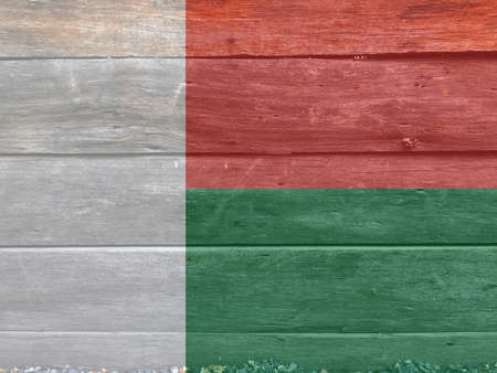 Flag of Madagascar on wooden wall background. Grunge Madagascar flag texture, Two horizontal bands of red and green with a white vertical band on the hoist side.の写真素材