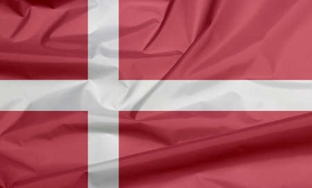 Fabric flag of Denmark. Crease of Danish flag background, red with a white Scandinavian cross that extends to the edges of the flag.の写真素材