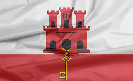 Fabric flag of Gibraltar. Crease of Gibraltar flag background, White and red stripe with three towered and hangs a gold key.の写真素材