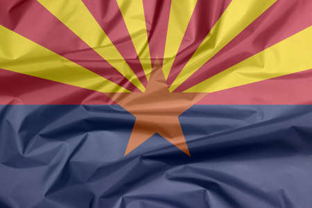 Fabric flag of Arizona. Crease of Arizona flag background, The states of America, red and yellow on the top half, with star and the rest of the flag is colored blue.の写真素材