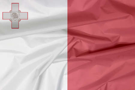 Fabric flag of Malta. Crease of Maltese flag background, A vertical of white and red with the representation of the George Cross edged.の写真素材