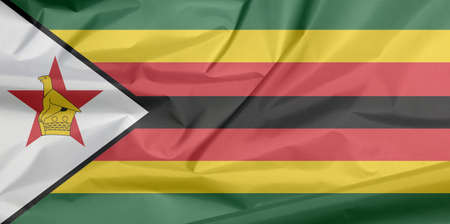 Fabric flag of Zimbabwe. Crease of Zimbabwean flag background, seven horizontal stripes of green yellow red black with a black-edged white with a bird on a red star.の写真素材