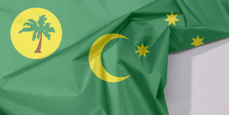 Cocos (Keeling) Islands fabric flag crepe and crease with white space, a palm tree on a gold disc, crescent and southern cross on green.の写真素材