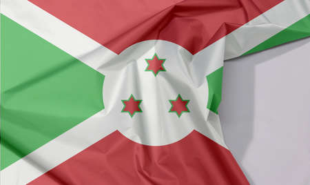 Burundi fabric flag crepe and crease with white space, A white diagonal cross divided into four panels of red and green and three star in the white disk in the center.の写真素材