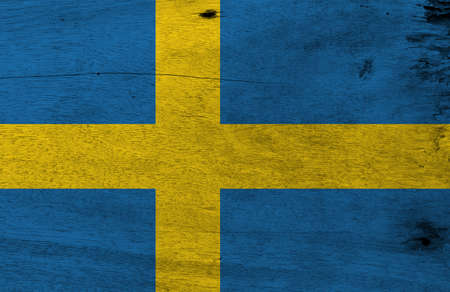 Flag of Sweden on wooden plate background. Grunge Sweden flag texture, it is consists of a yellow or gold Nordic Cross on a field of blue.の写真素材