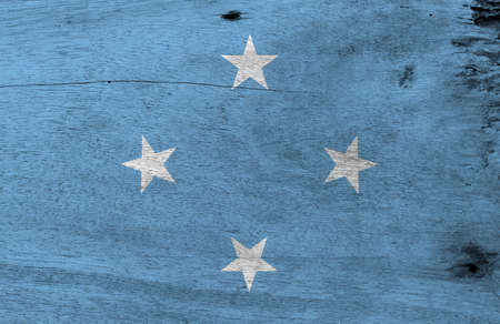 Flag of Federated States of Micronesia on wooden plate background. Grunge Federated States of Micronesia flag texture, A light blue field with four stars arranged in the diamond pattern.の写真素材