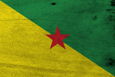 Flag of French Guiana on wooden plate background. Grunge French Guiana flag texture, The green and yellow with red star.の写真素材