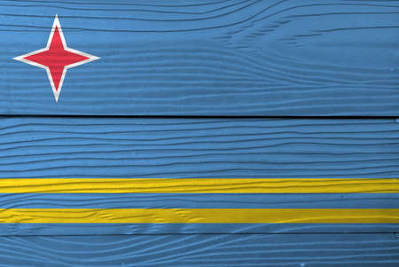 Flag of Aruba on wooden wall background. Grunge Aruba flag texture, light blue and two narrow parallel horizontal yellow stripes in the bottom half, and red star.の写真素材