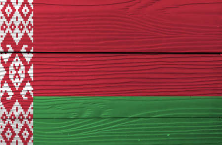 Flag of Belarus on wooden wall background. Grunge Belarus flag texture, red over green in a 2:1 ratio, with a red ornamental pattern on a white vertical stripe at the hoist.の写真素材