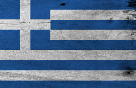 Flag of Greece on wooden plate background. Grunge Greek flag texture, Nine stripes of blue and white; a white cross on a blue square.の写真素材