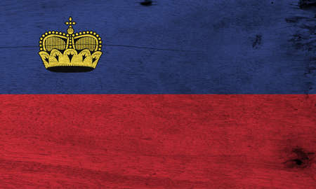 Flag of Liechtenstein on wooden plate background. Grunge Liechtensteiner flag texture, blue and red, charged with a gold crown.の写真素材