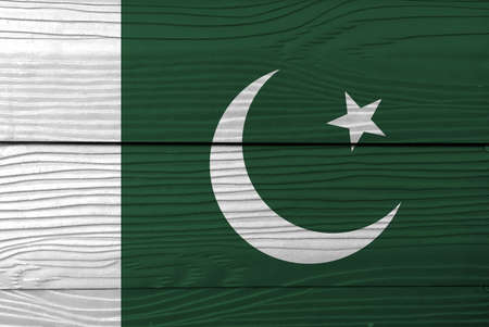 Flag of Pakistan on wooden wall background. Grunge Pakistani flag texture, a white star and crescent on a dark green field, with a vertical white stripe at the hoist.の写真素材