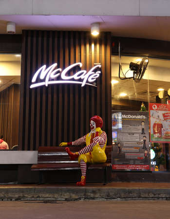 Muang, Samutsakhon,Thailand, Dec 31, 2018: A Ronald McDonald statue, mascot sitting in front of McCafe coffee shop on night view at Porto Chino Community Market.のeditorial素材