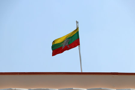 Myanmar flag blown by the wind on the roof with blue sky background.の写真素材