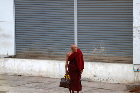 Yangon, Myanmar Feb 24, 2019: Myanmarese Buddhist monk standing beside the road in Yangon.のeditorial素材