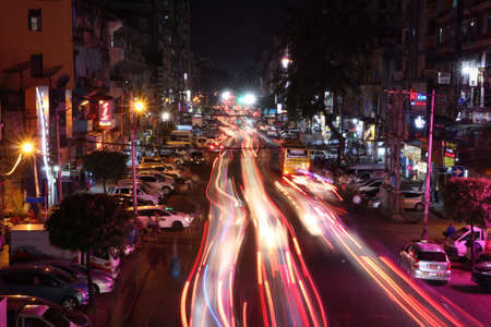 Yangon, Myanmar Feb 21, 2019: Night time and speed of light at Anawrahta Rd. with the car people and building.のeditorial素材