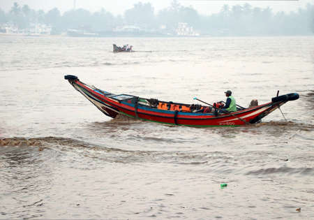 Yangon, Myanmar, Feb 24, 2019: Myanmar traditional ferry driving with passenger at Yangon river on the morning.のeditorial素材