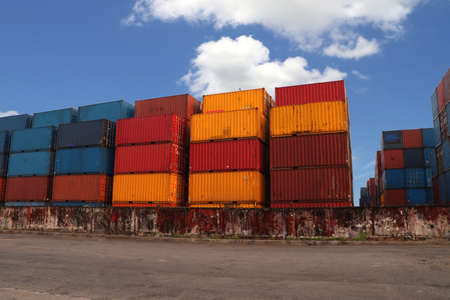Shipping Containers placed as layered in the storage facility on blue sky background. an object that can be used to hold or transport something.の写真素材