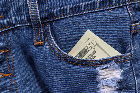 Banknote money twenty US dollar in the pocket of blue jeans. Concept of saving money or finance.