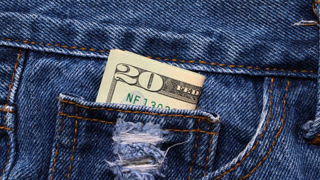 Banknote money twenty US dollar in the mini pocket of blue jeans. Concept of saving money or finance.の写真素材