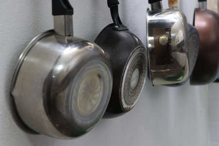 Metal pans and pots for cooking, hanging in the kitchen.