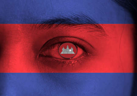 Human face painted Cambodian flag with Angkor wat on the center of eye or eyeball. Human eye painted with flag of Cambodia.の写真素材