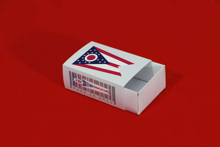 Ohio flag on white box with barcode and the color of state flag on red background, paper packaging for put match or products. The concept of export trading from Ohio. Ohio flag on white box with barcode and the color of state flag on red background, paper packaging for put match or products. The concept of export trading from Ohio.